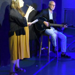 En person sjunger och en annan spelar gitarr