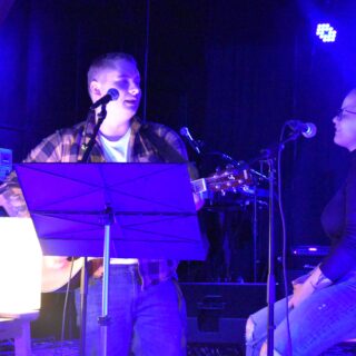 Två personer sjunger och en spelar gitarr