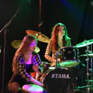 Två personer spelar på trummor