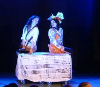 Två personer sjunger i en teaterföreställning