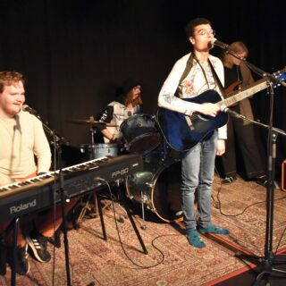 4 Personer spelar i ett band, piano, trummor, gitarr och bas