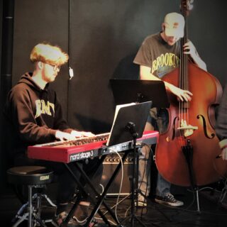 Två personer spelar instrument, en ståbas och en på piano