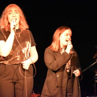 Två personer sjunger i mikrofon