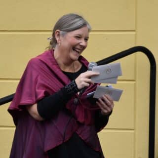 Rektor Anna skrattar medans hon delar ut biokort.